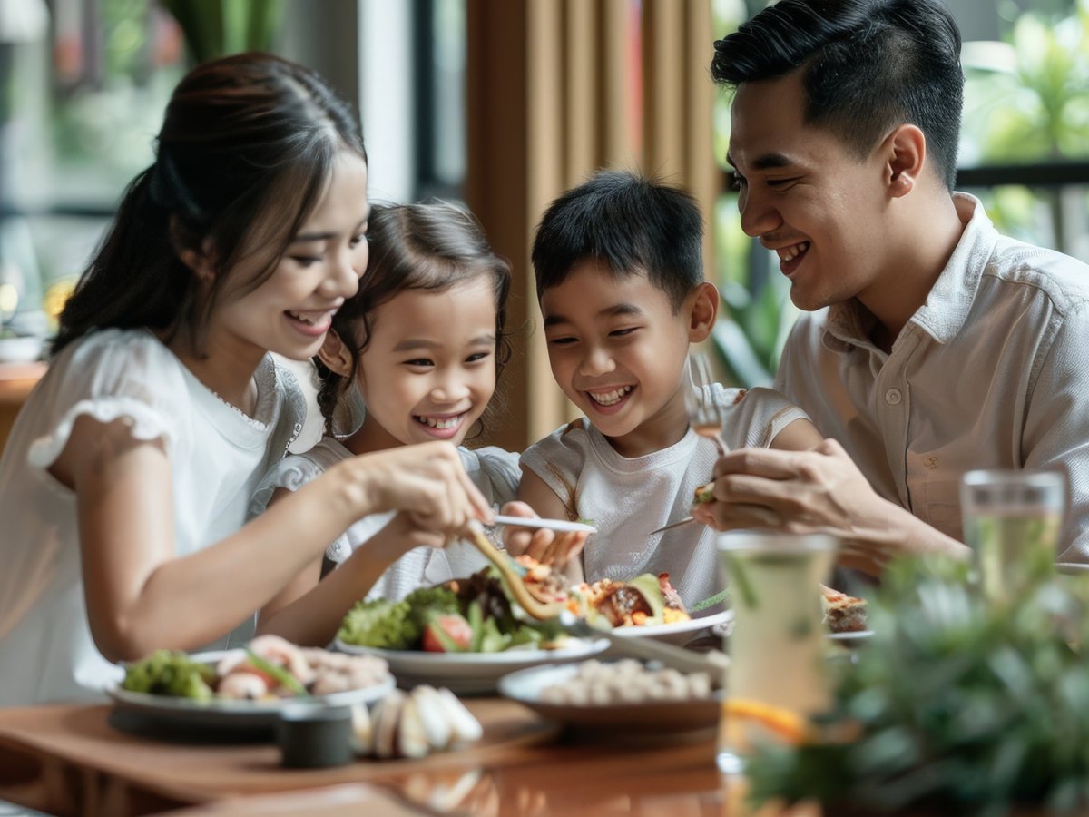 A family of four sharing a meal at a restaurant table
