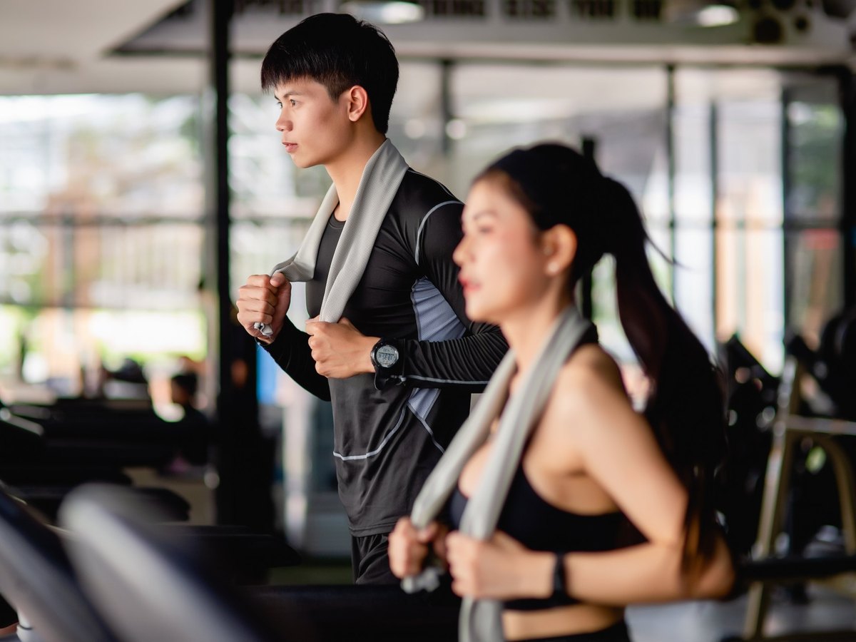 A man and a woman running on treadmills in a gym